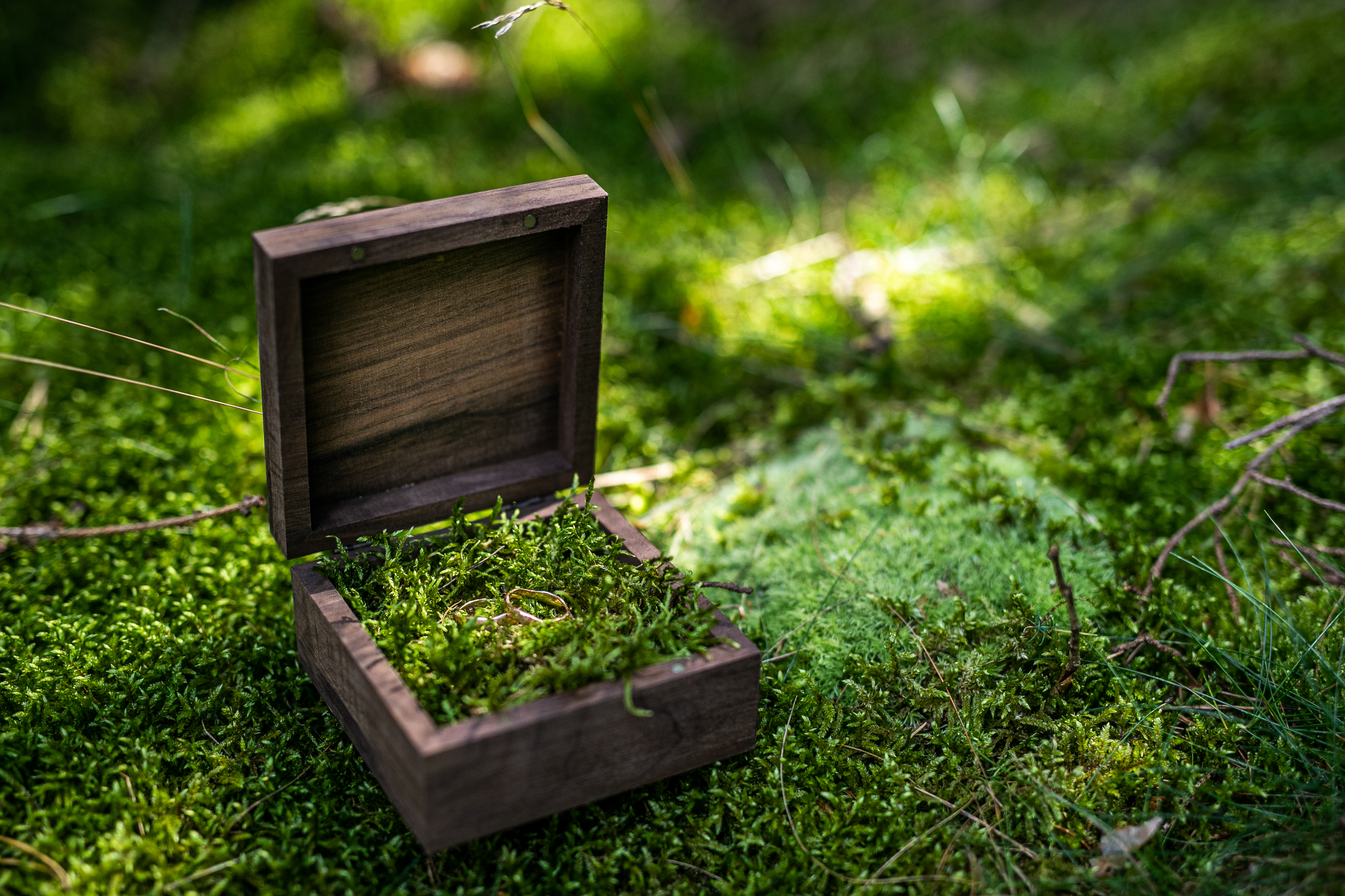 Otevřená dřevěná krabička na prsteny vyplněná mechem